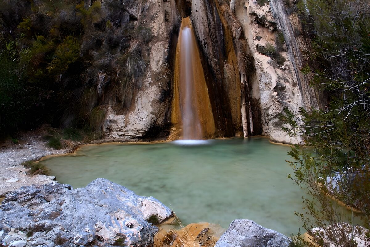 Secluded waterfall and pale green pool