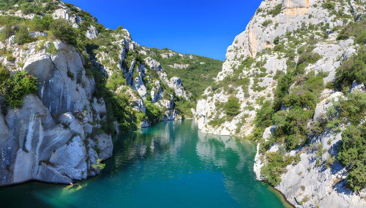 Turquoise water between sunlit cliffs