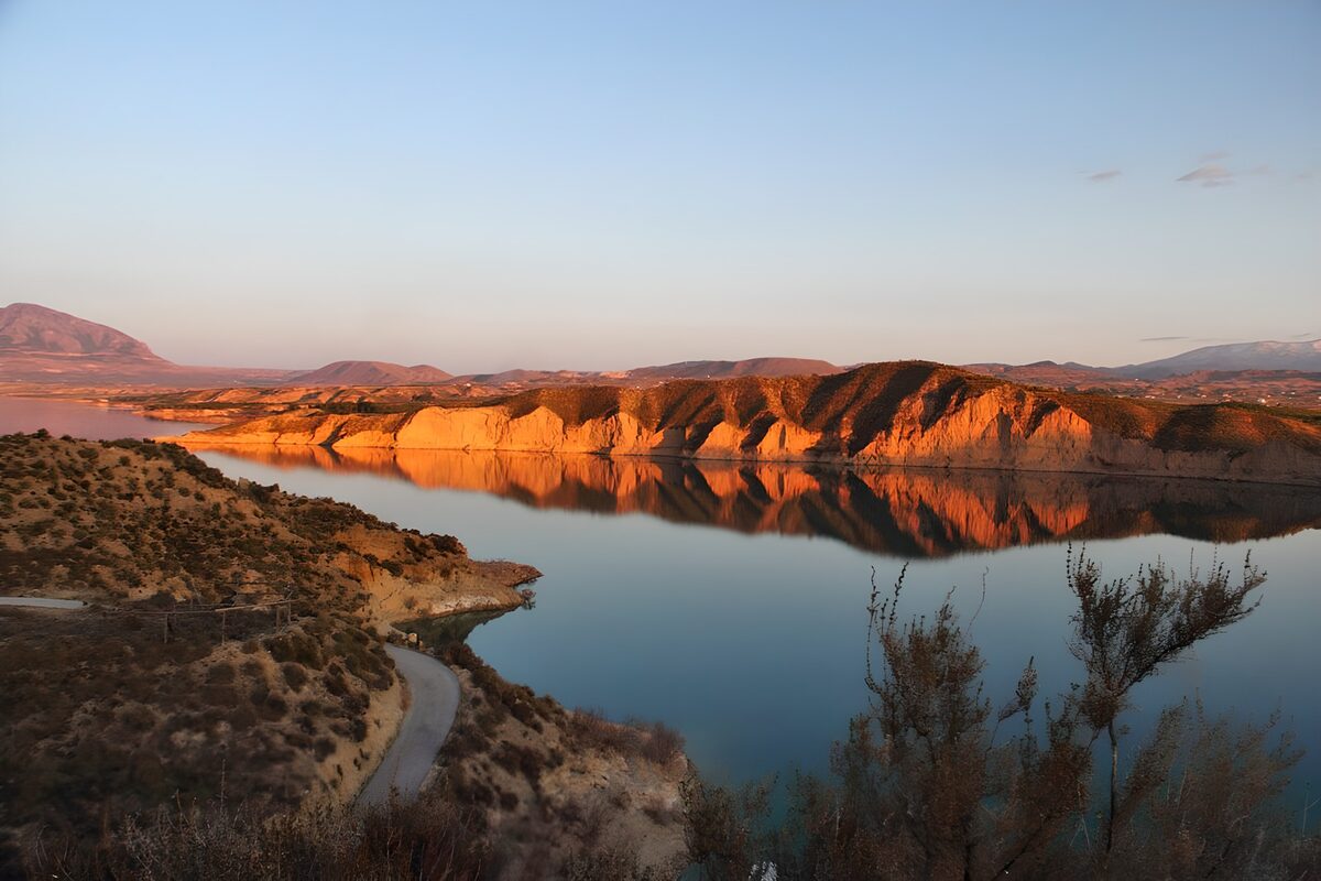 Still lake and cliffs in golden light