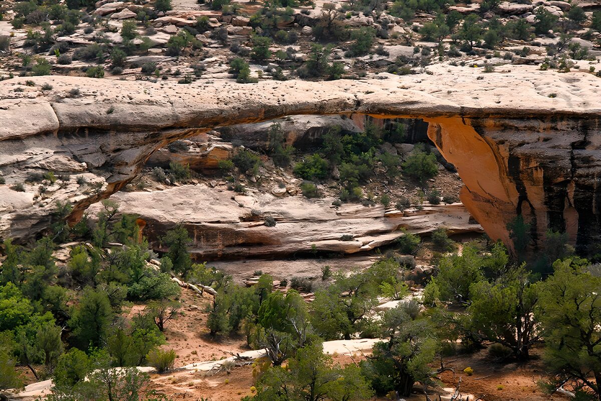 Sunlit rock arch over a rugged ravine