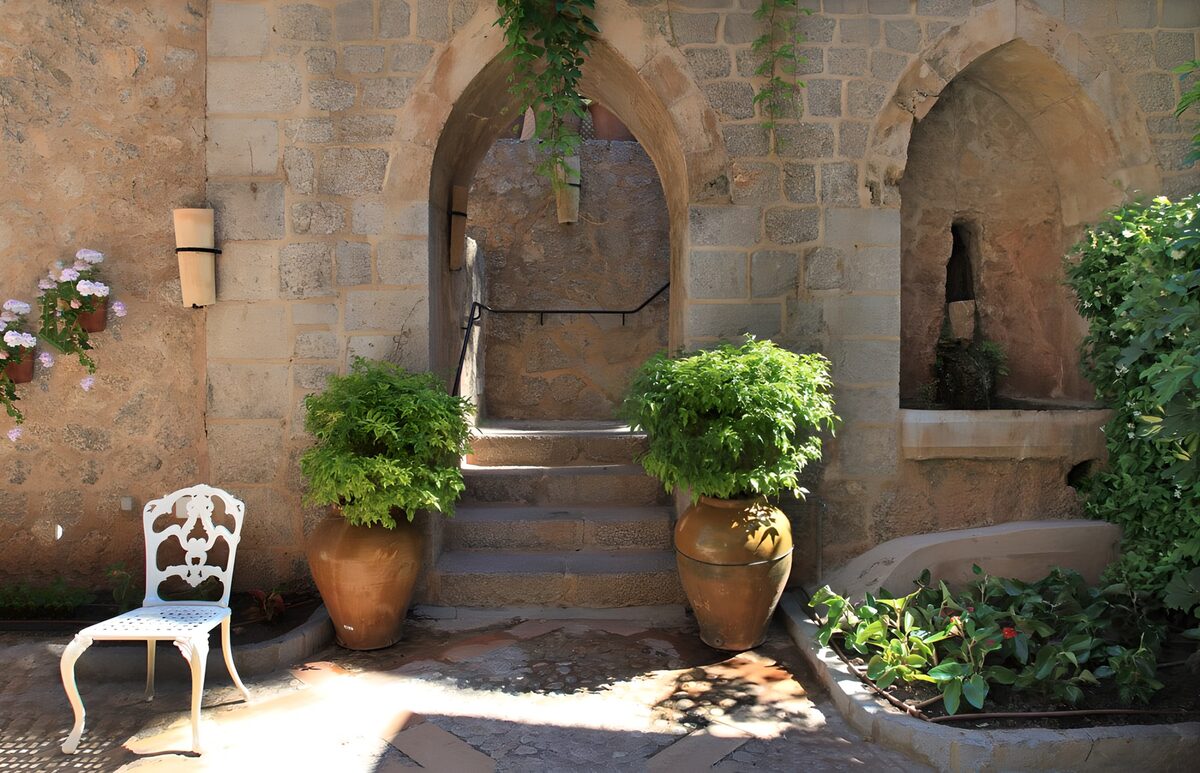 Stone courtyard with sunlit arches