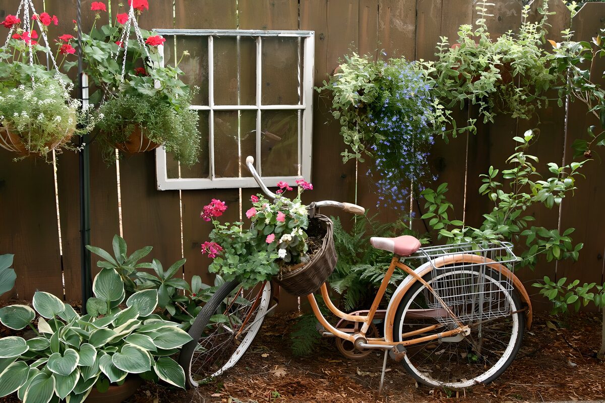 Old orange bicycle among garden flowers