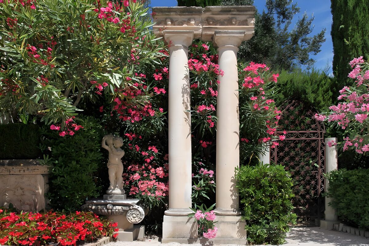 Stone columns in a sunlit flower garden