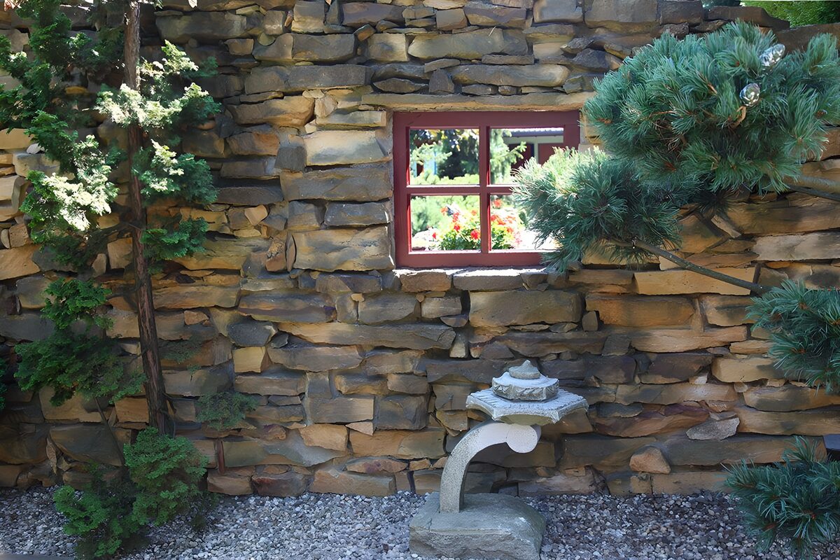 Red window in a quiet stone-walled garden