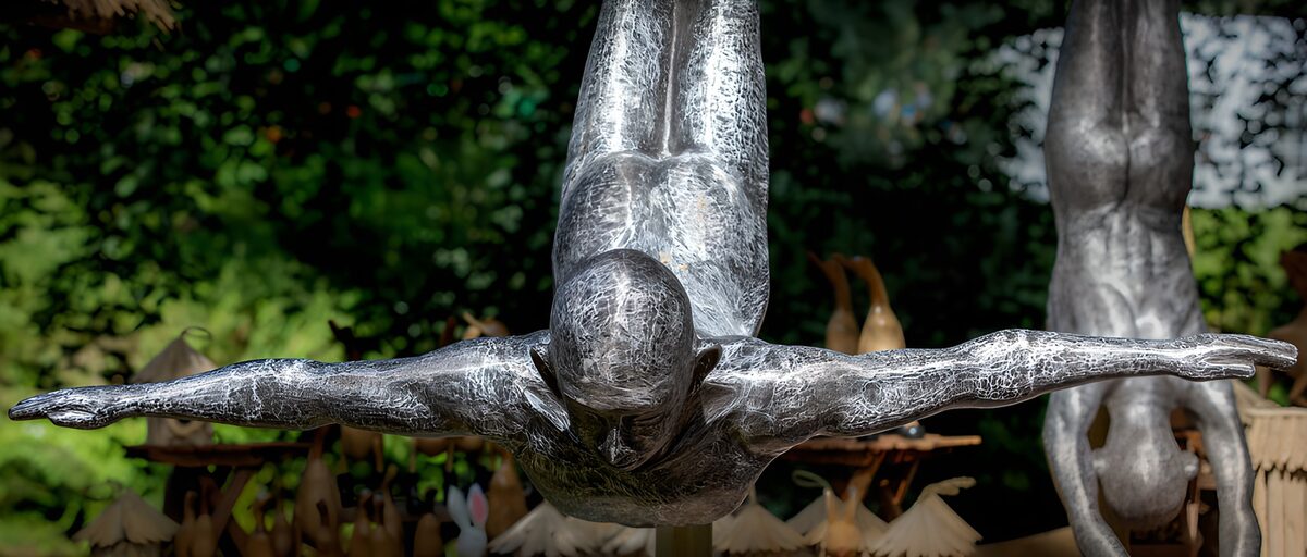 Metal diver poised with arms outstretched