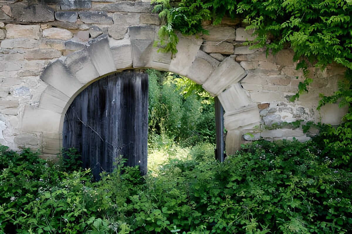 Old stone arch and weathered wooden gate