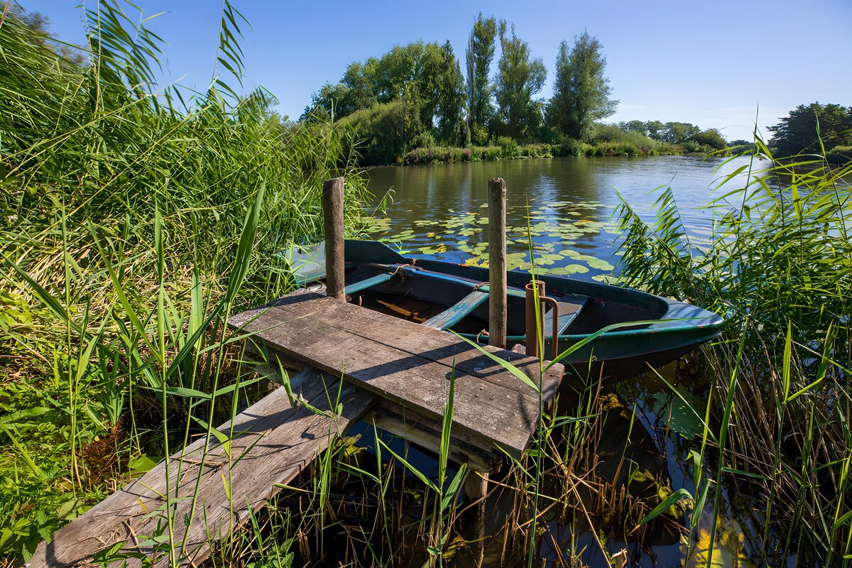 Green rowing boats at a quiet wooden jetty