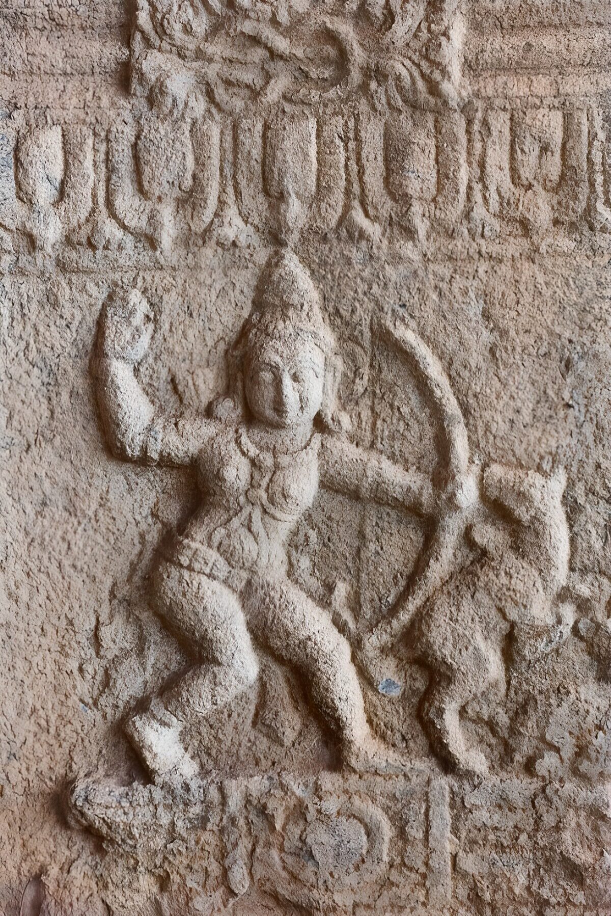 Weathered stone figure with a bow
