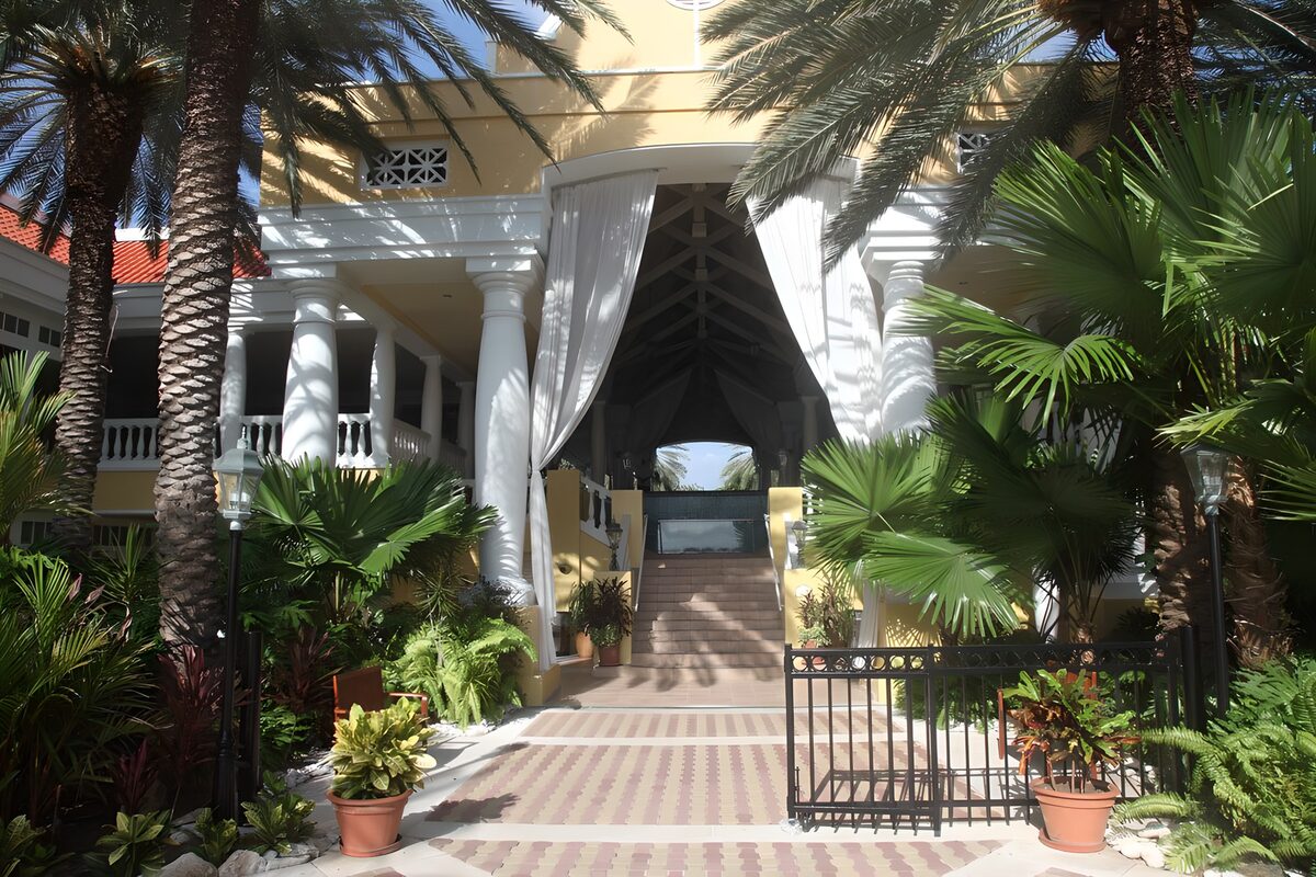 Palm-framed entrance in pale yellow