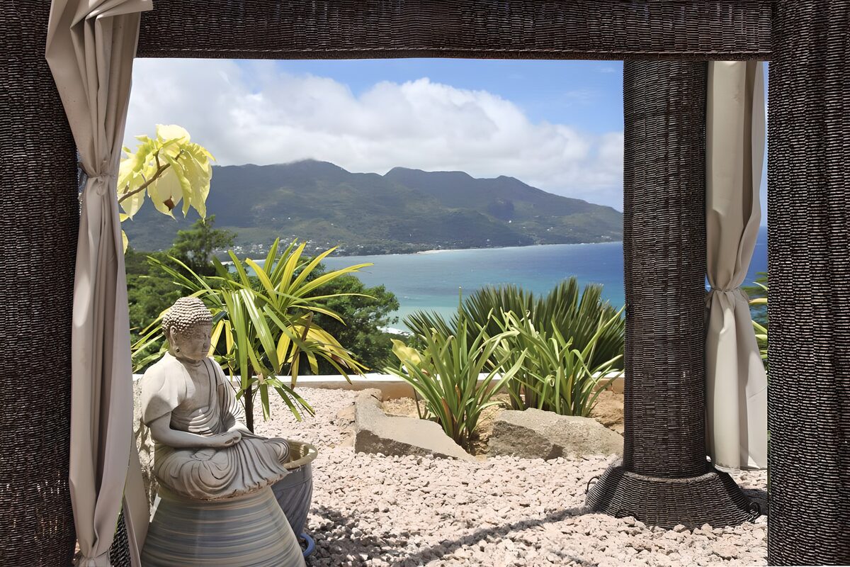 Buddha statue on a sunlit coastal terrace