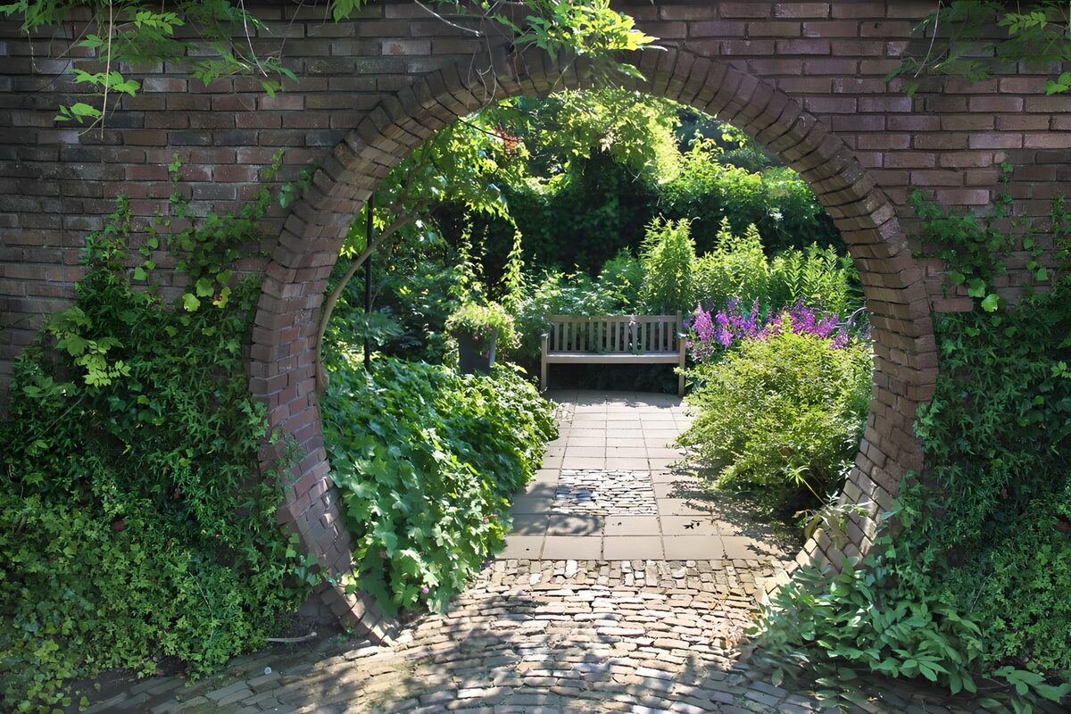 Brick arch into a sunlit garden