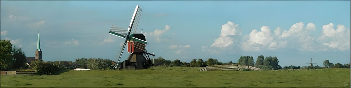 Windmill in a sunlit green meadow