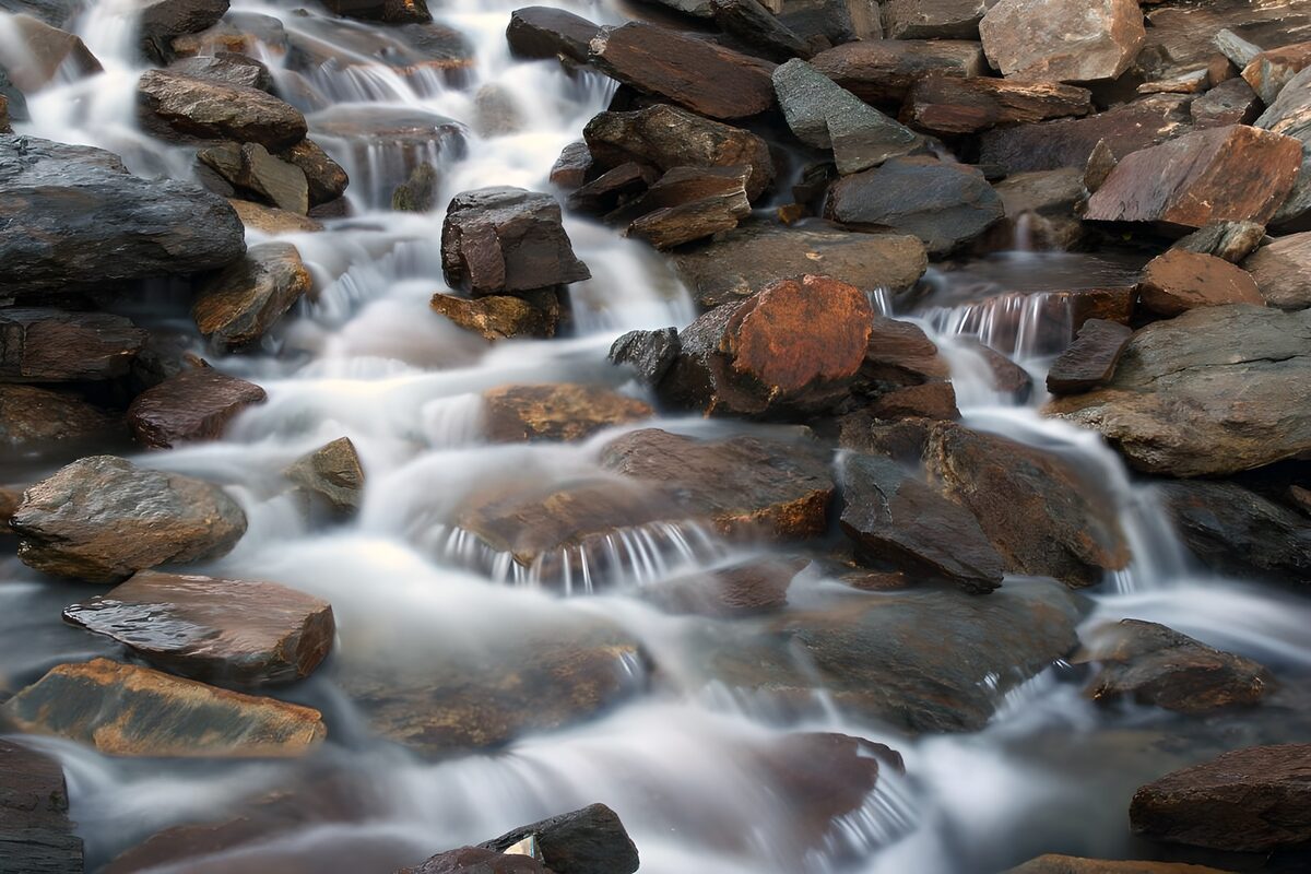 Soft cascades over dark boulders