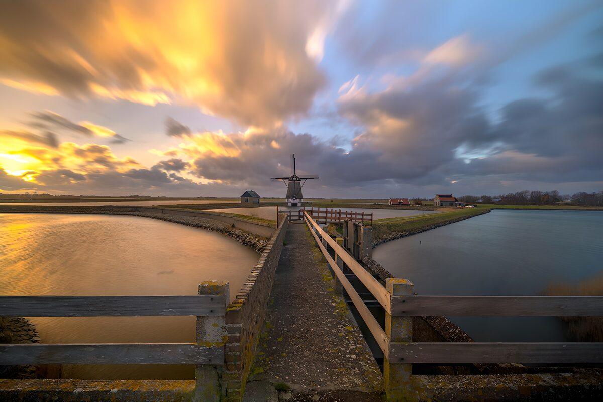 Windmill beyond the bridge at sunset