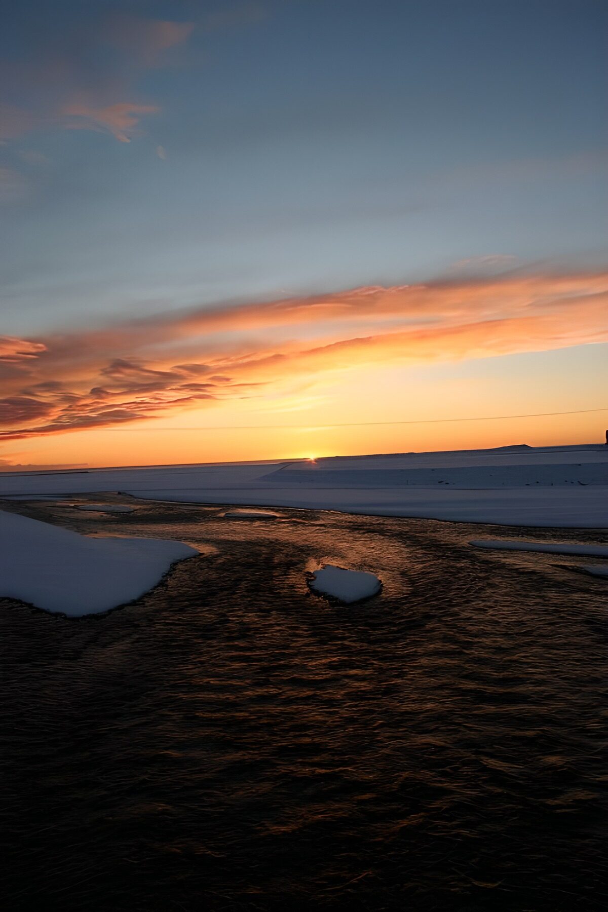 Low winter sun over snow and water