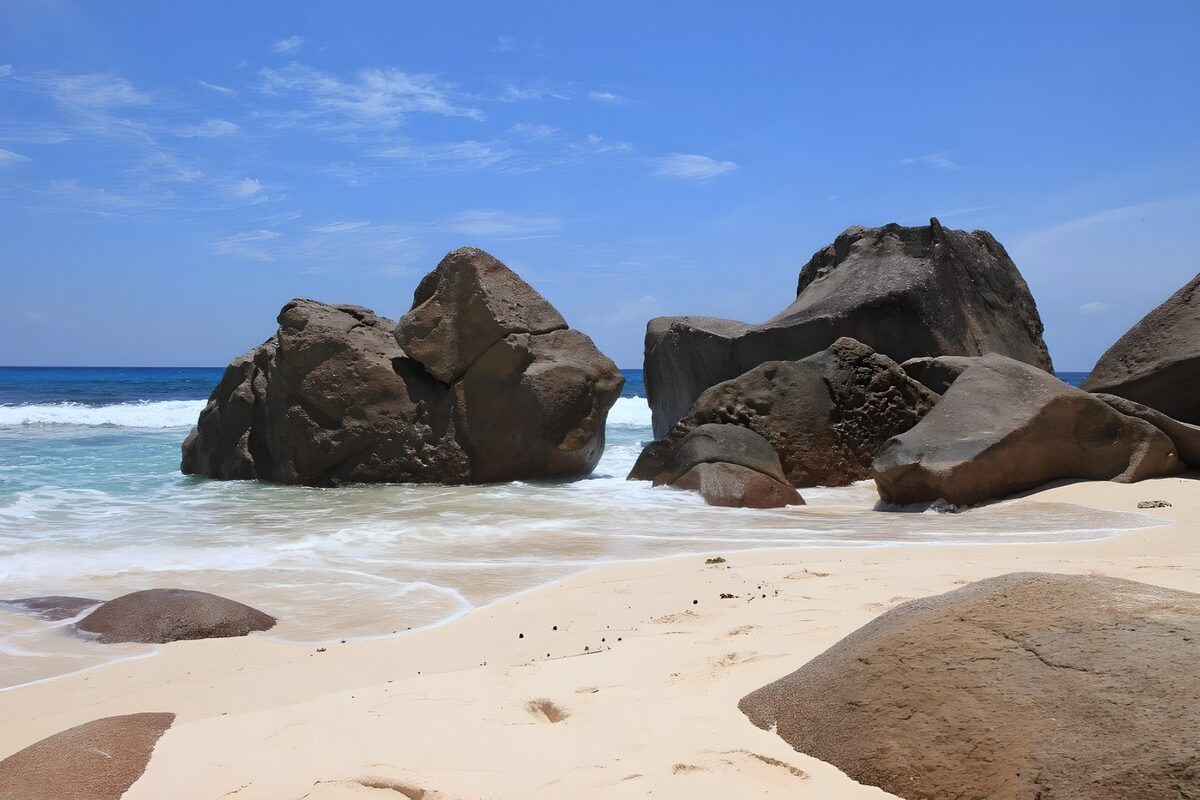 Sunlit boulders on a sandy beach