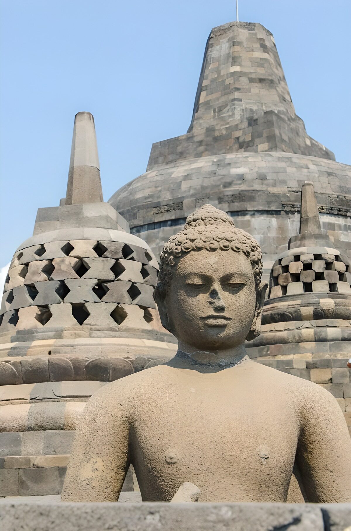 Sunlit stone Buddha and Borobudur stupas