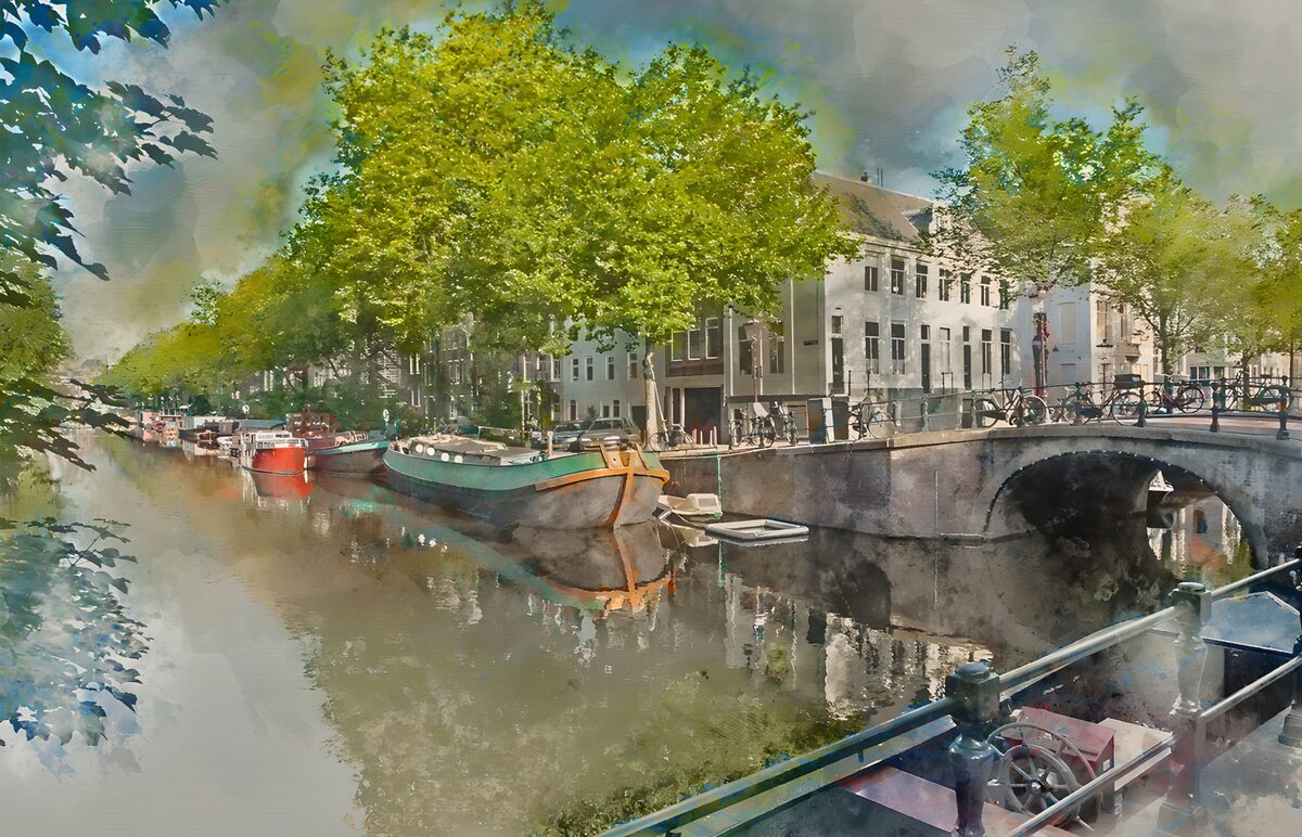 Leafy canal with boats and a stone bridge