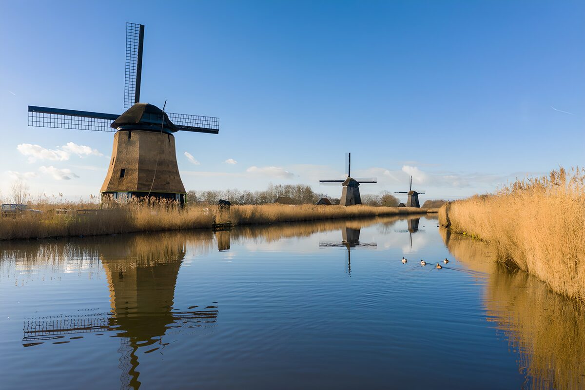 Windmills mirrored in a ribbon of blue