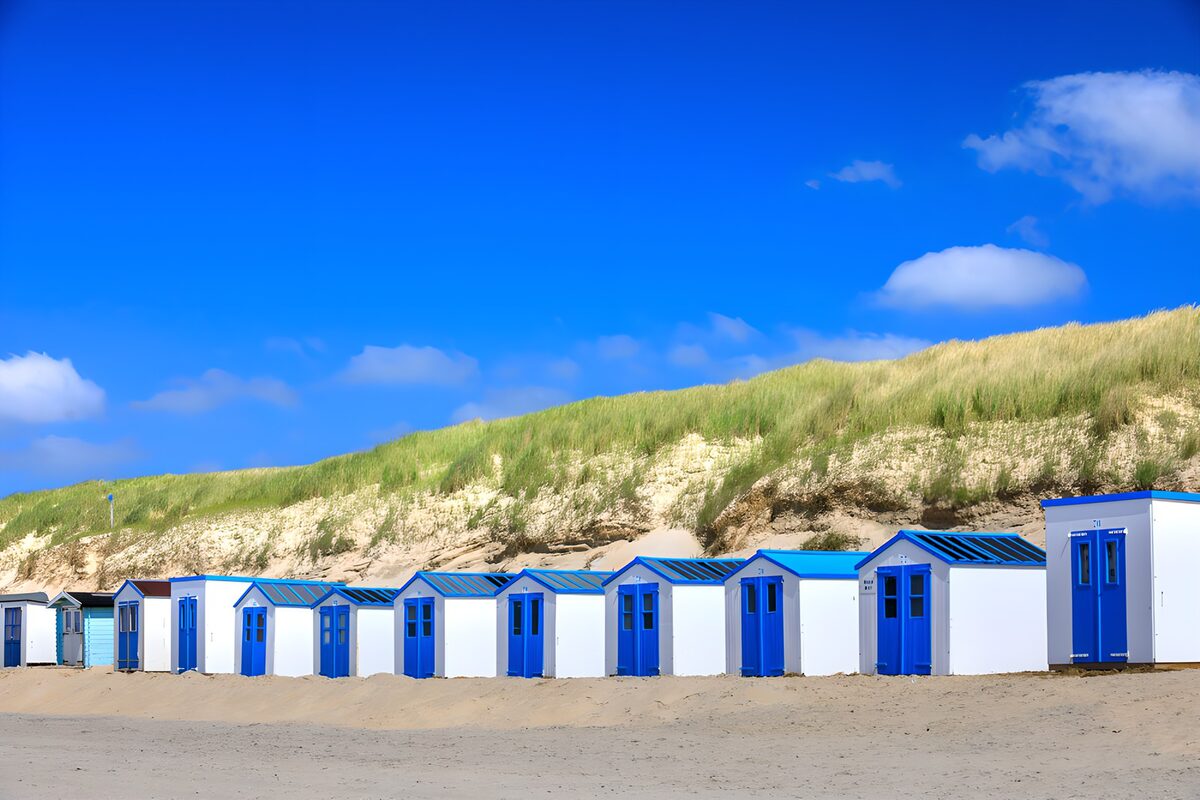 Blue and white beach huts on quiet sands