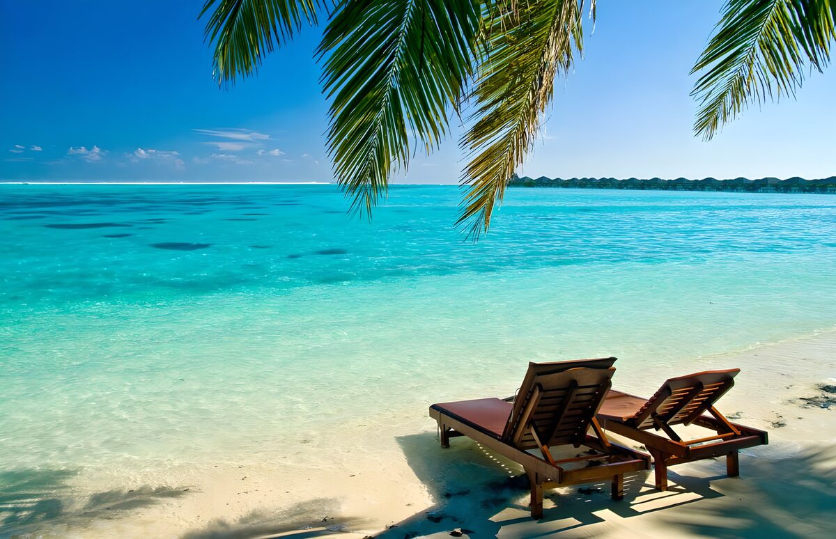 Two sun loungers by a turquoise sea