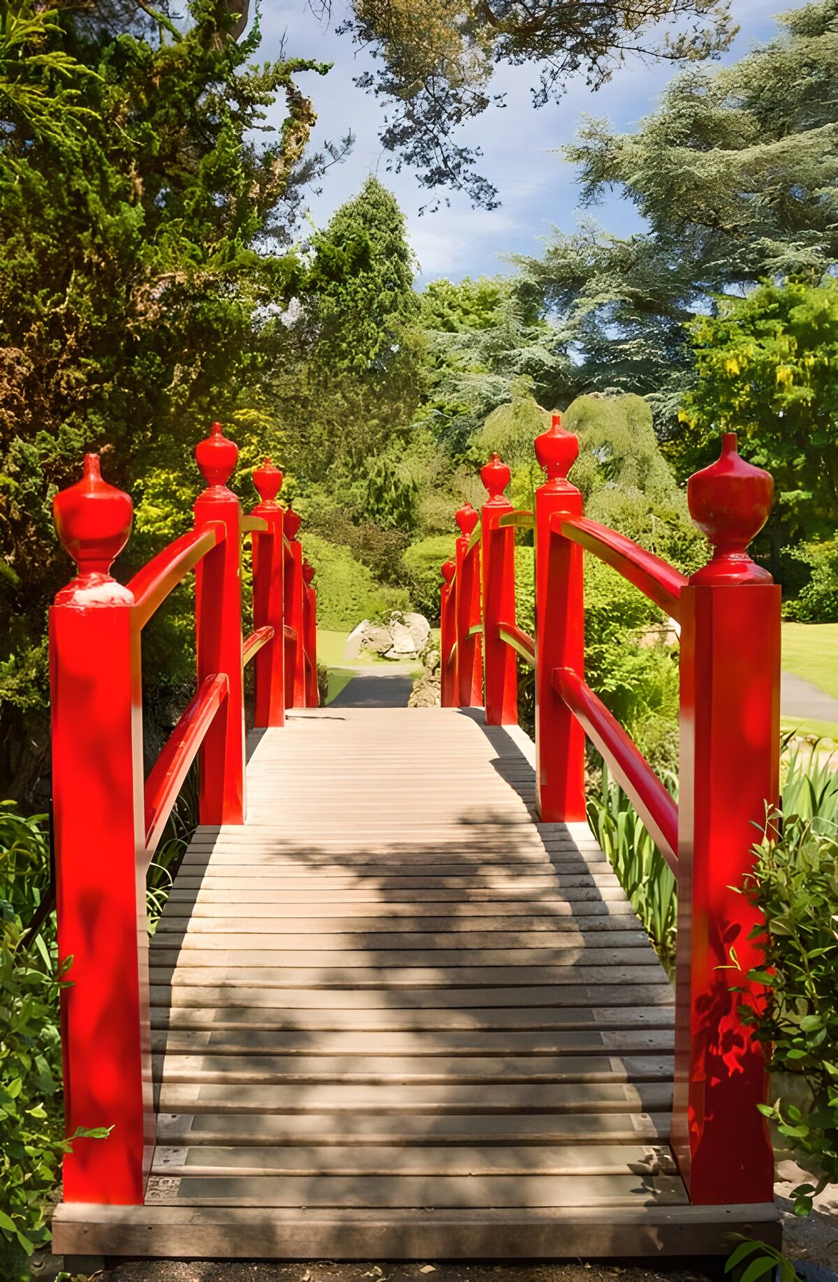 Red wooden bridge in dappled sunlight