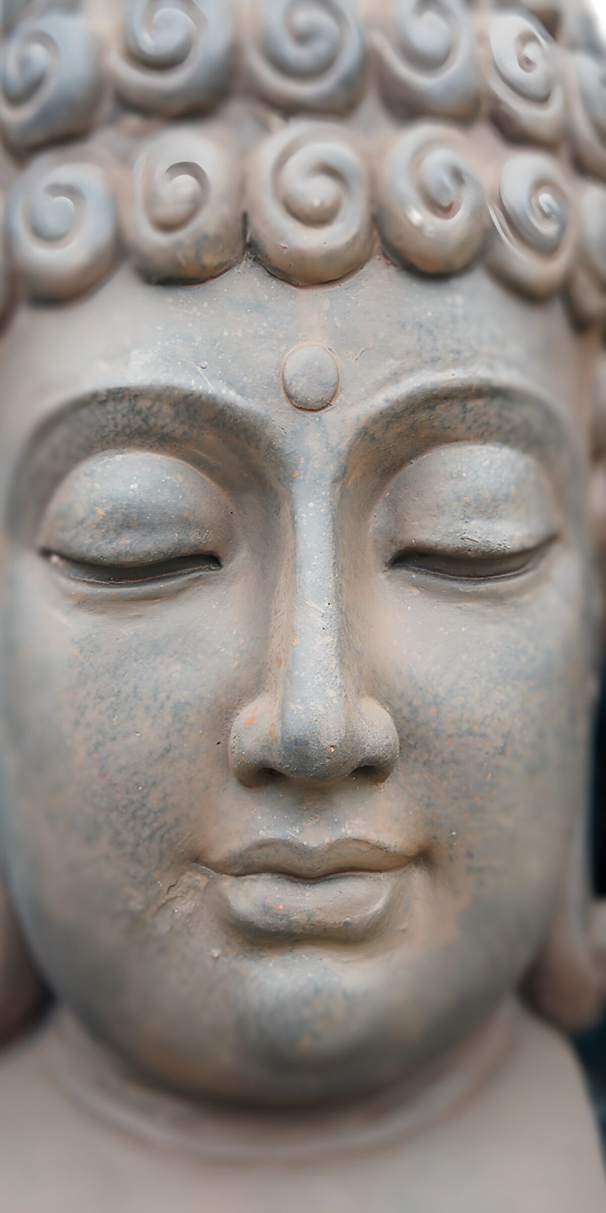 Weathered Buddha face with closed eyes