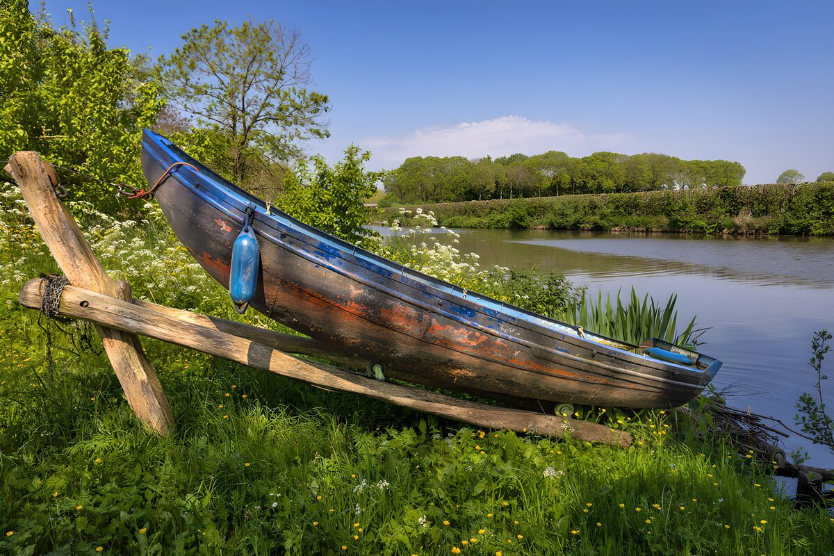 Weathered boat on a quiet grassy bank