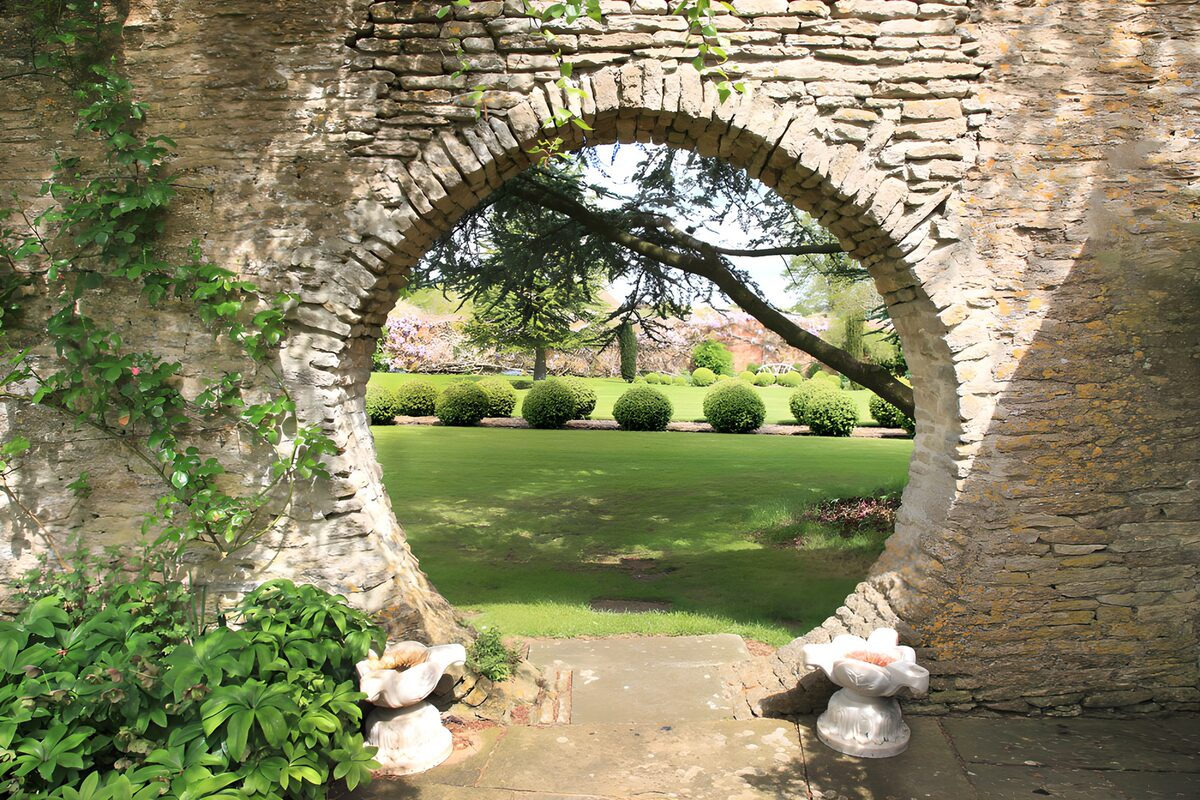 A stone arch framing a hush of green