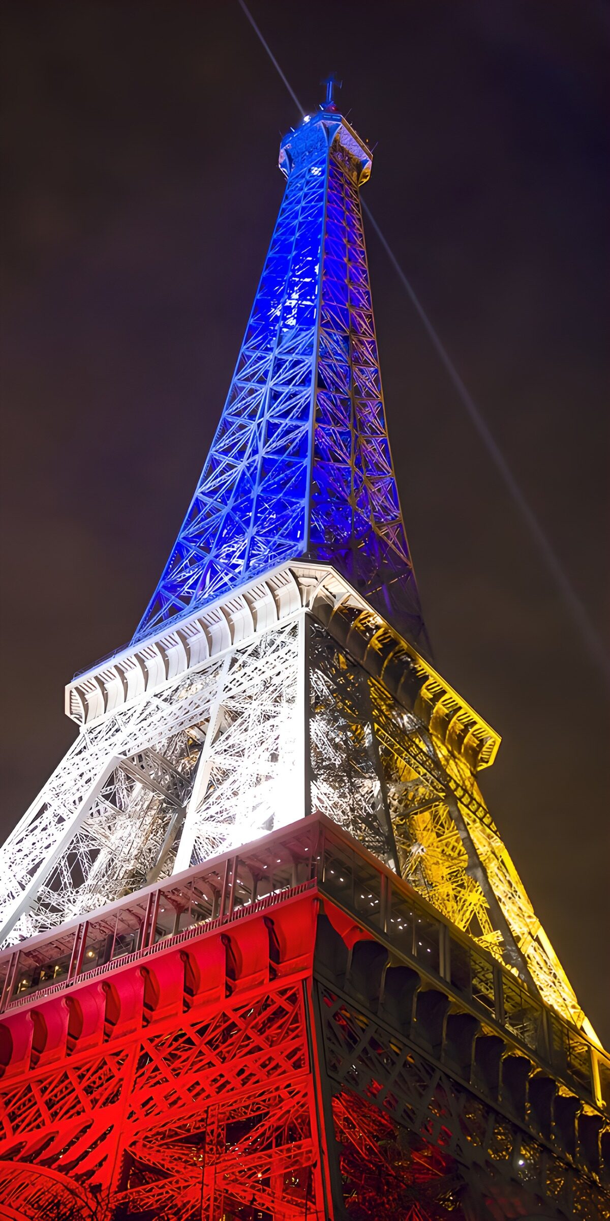 Eiffel Tower lit in red, gold and blue