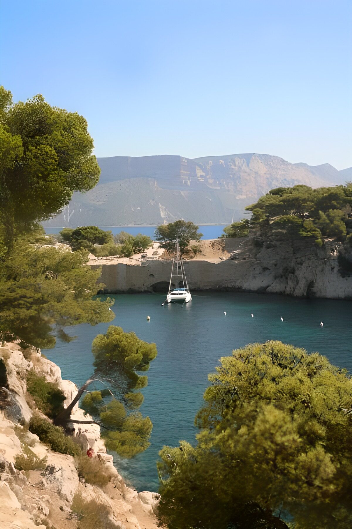 White yacht in a sunlit rocky cove