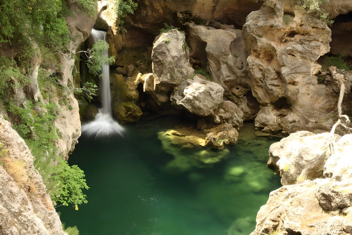 Waterfall and green pool between rocks