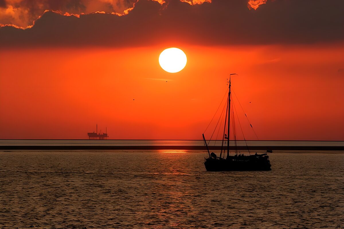 Sailboat silhouette on an orange sea