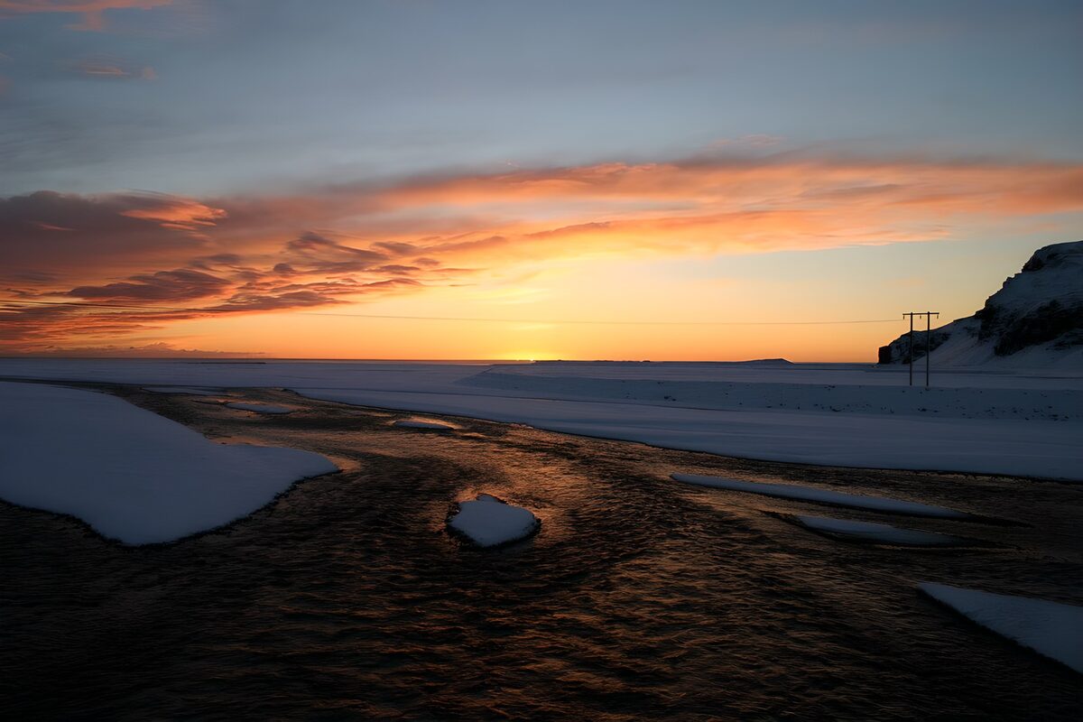 Snow-lined stream at sunset
