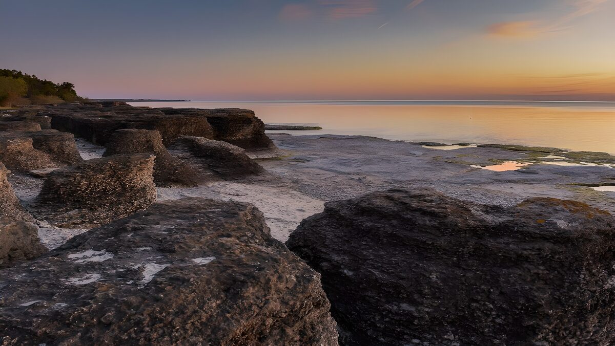 Rocky coast beneath a pastel sunset