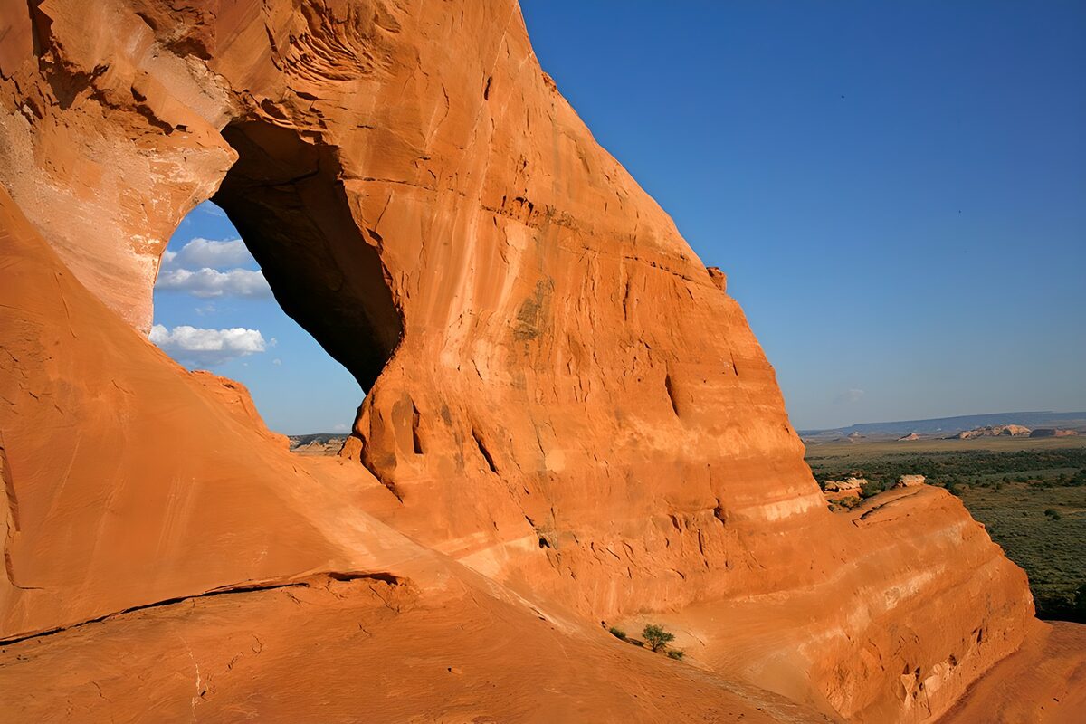 Sunlit sandstone arch above the desert