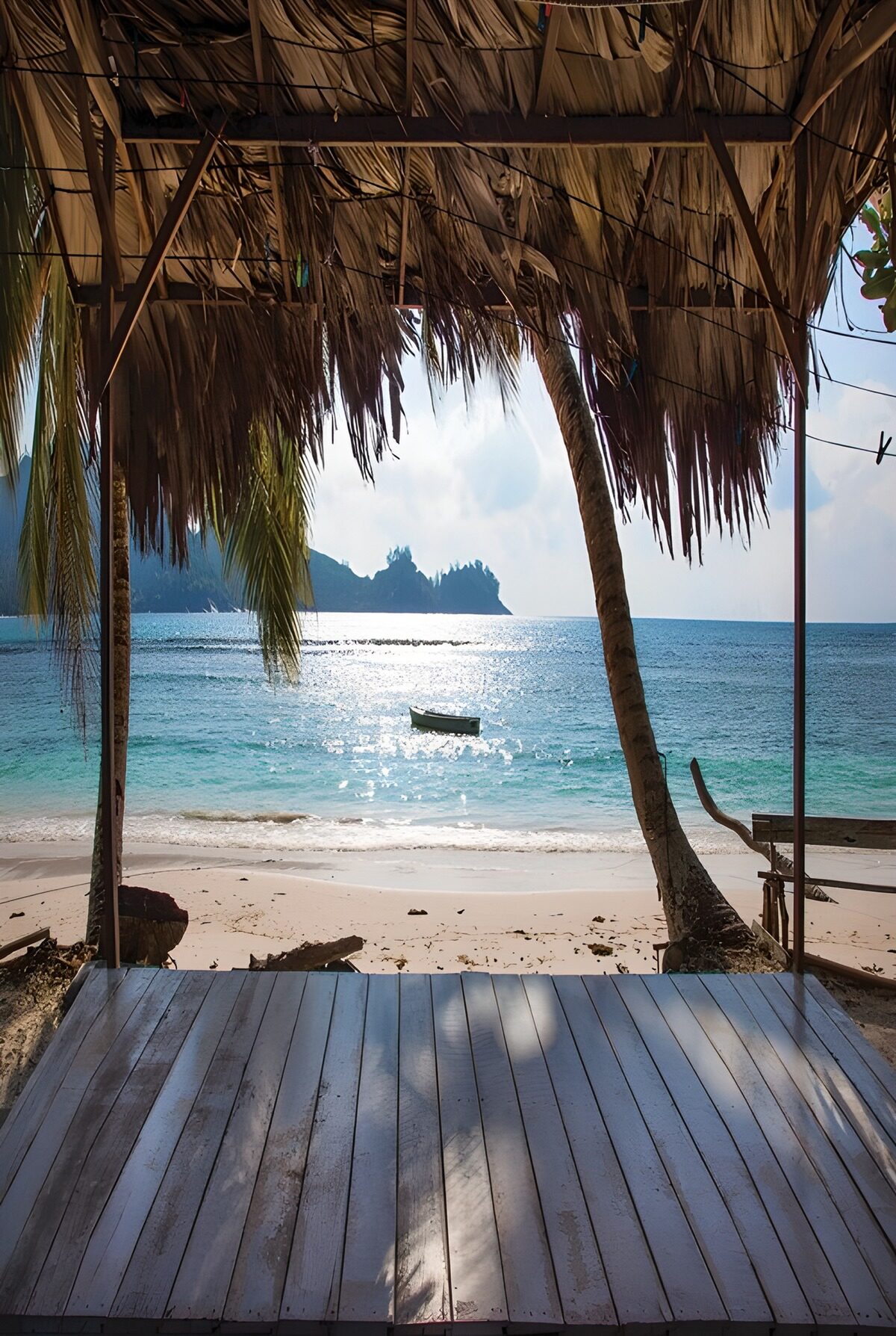 Beach view from a palm-thatched shelter