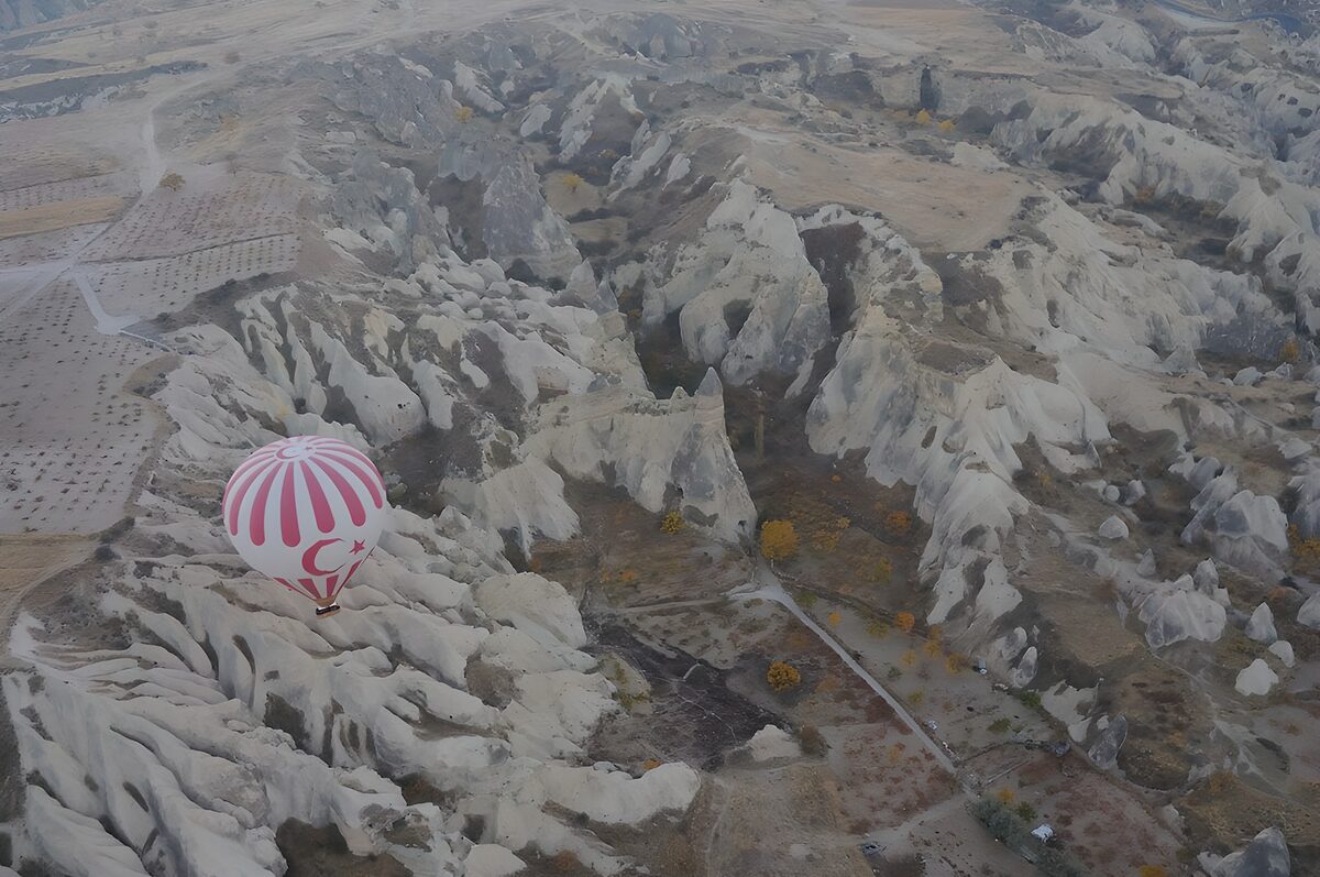 Pink balloon over an eroded valley