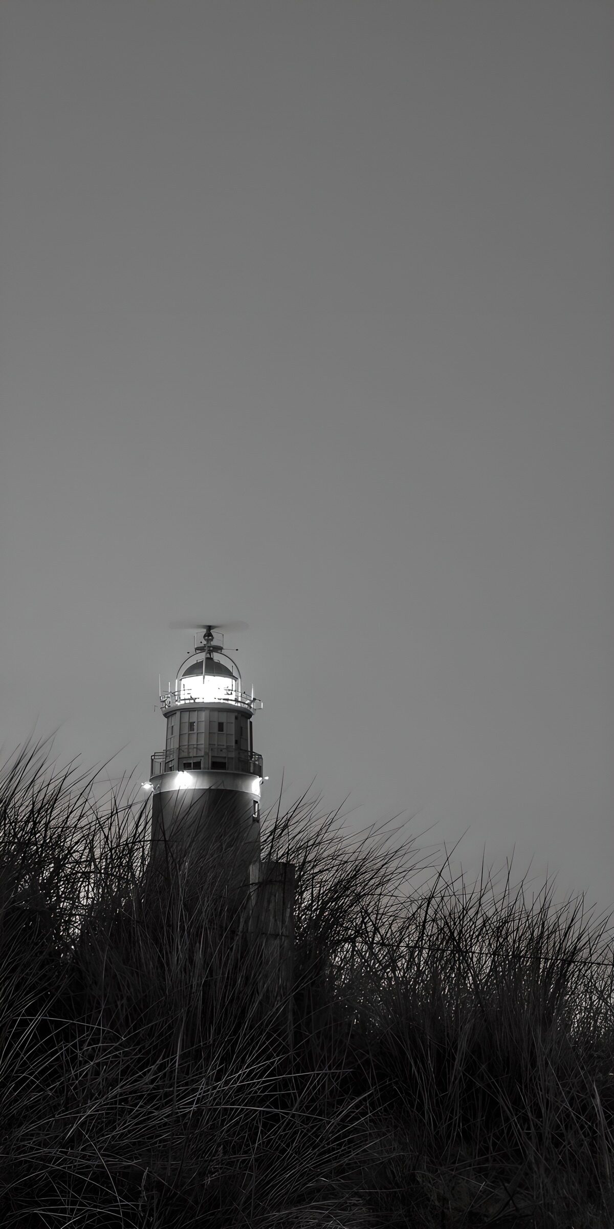 Lighthouse behind dune grass