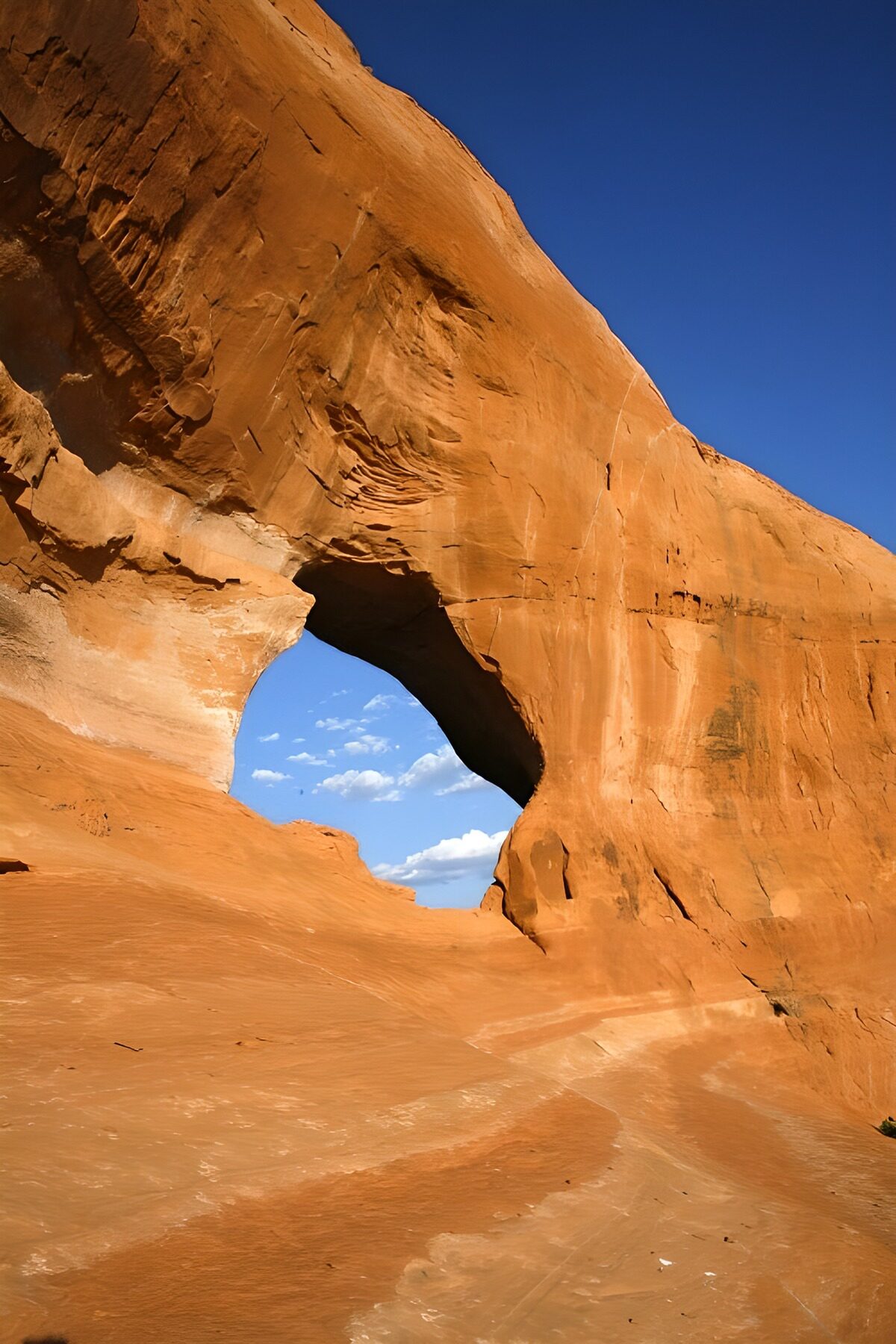 Sunlit sandstone arch against blue sky