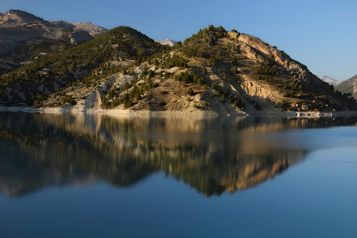 Sunlit slopes above a blue mountain lake