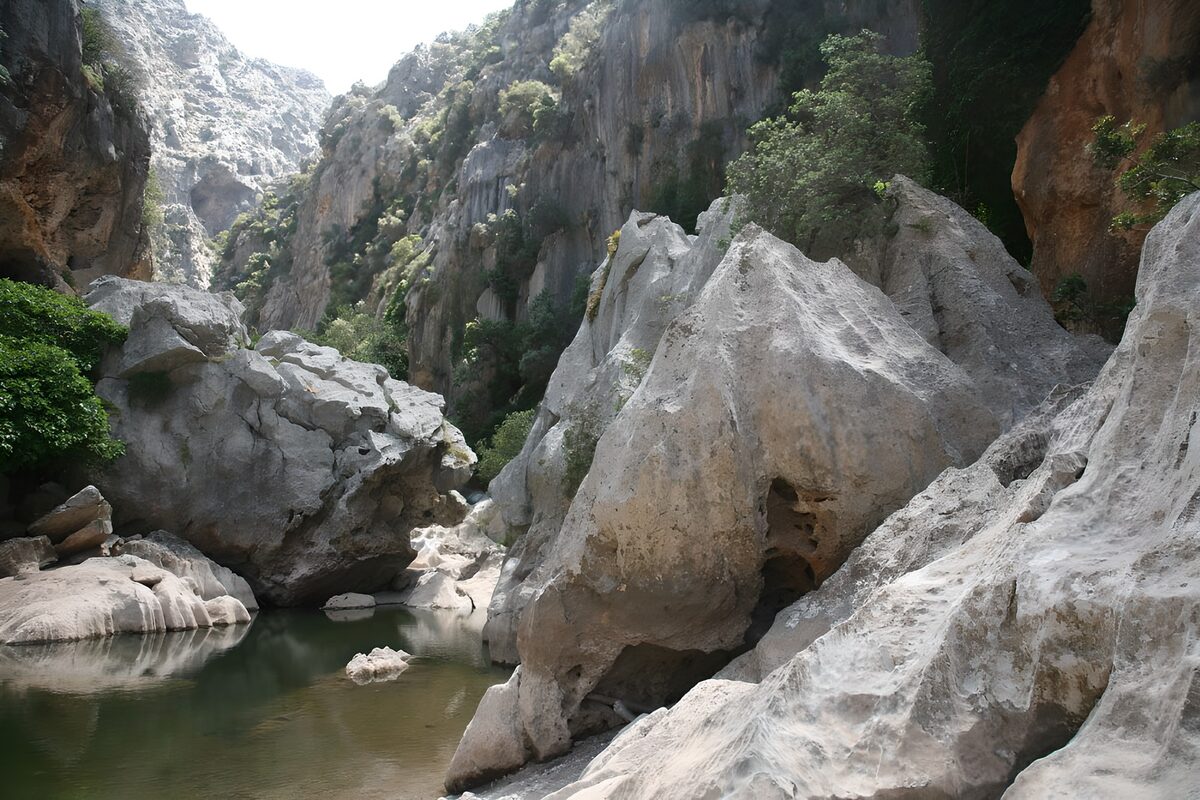 Green pool beneath rugged cliffs