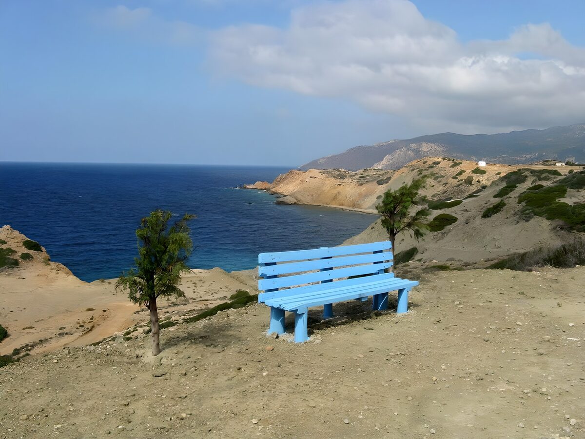 Blue bench above a quiet coastal bay