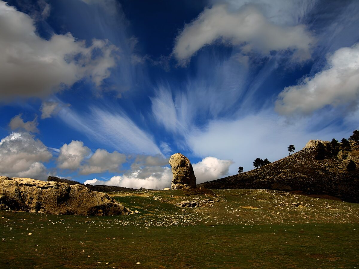 Sunlit rocks beneath a vast blue sky