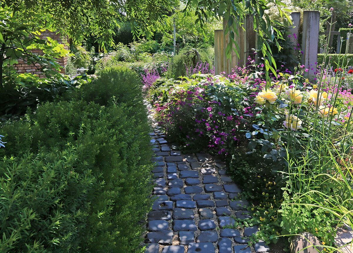 Sunlit stone path through a lush garden