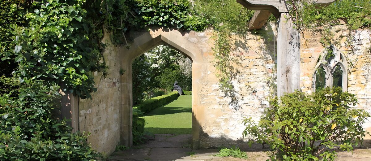 Sunlit garden through a stone arch