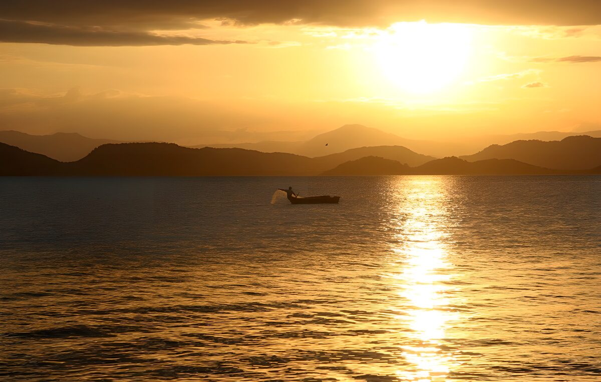 Fisherman casting a net at sunset