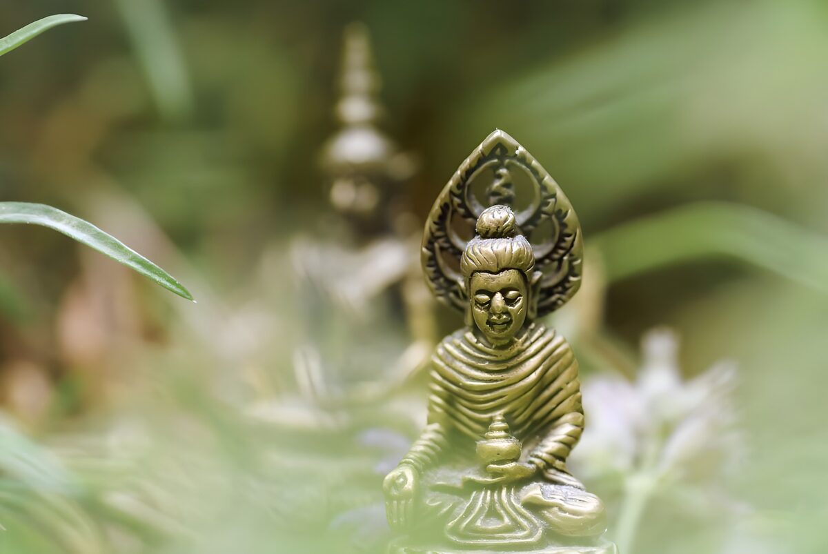 Golden Buddha among soft green leaves