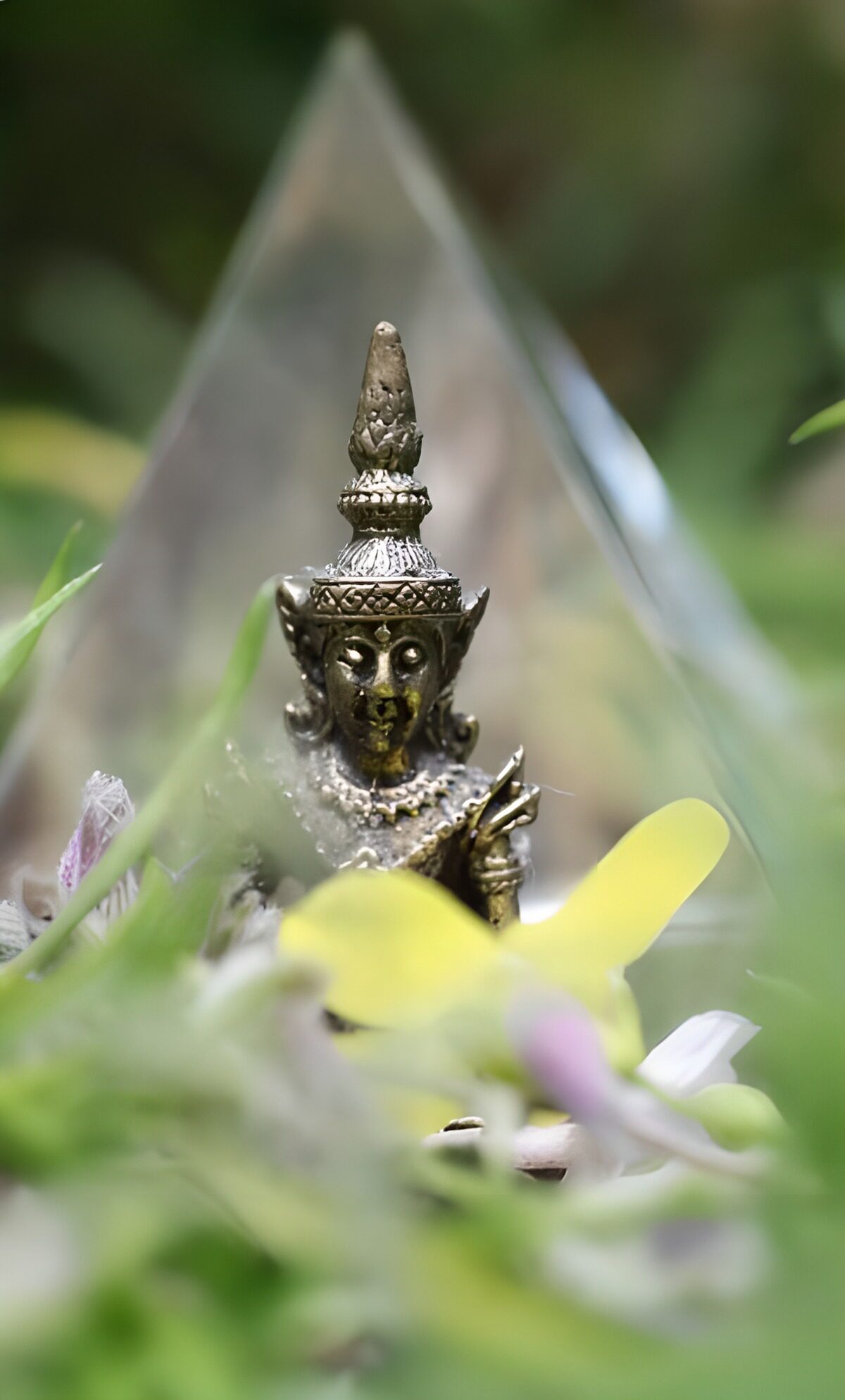 Bronze-coloured Buddha among soft blooms